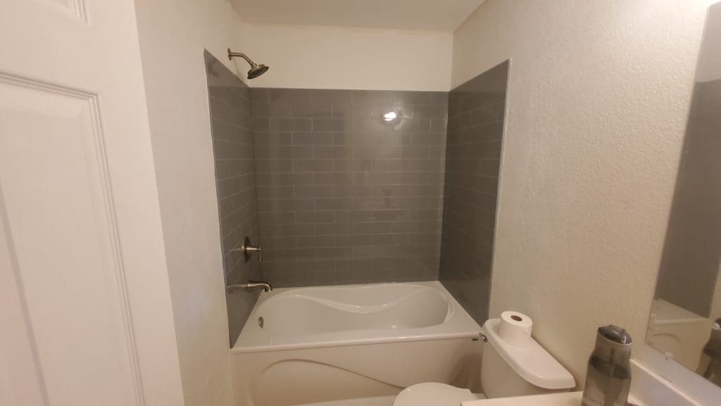 White bathroom remodel with grey shower tile
