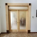 Interior French doors with light wood frame and frosted glass panels featuring decorative etched patterns built by CNT Builders in Spearfish, SD.