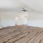 New wood-look vinyl plank flooring installed by CNT Builders, a flooring contractor in Spearfish, SD, in a modern open-concept living space with a corner fireplace